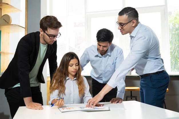 Team of angel investor financial services professionals collaborating on investment analysis documents