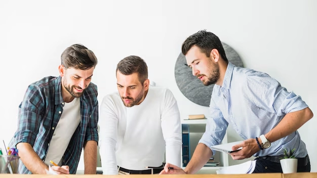 Three angel investors discussing financial services opportunities in relaxed modern office environment