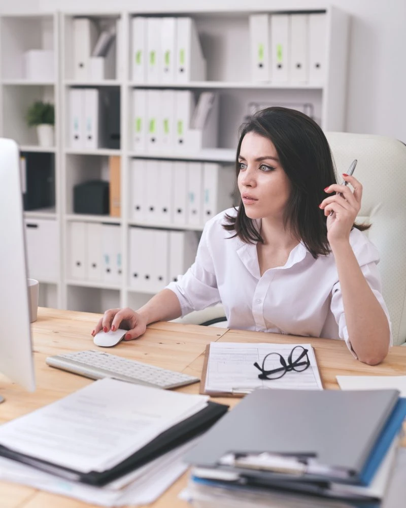 Expert accountant for lottery winners reviewing documents with pen in organized office workspace