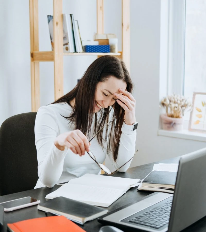 Stressed expert accountant for lottery winners working intensely on laptop with financial documents
