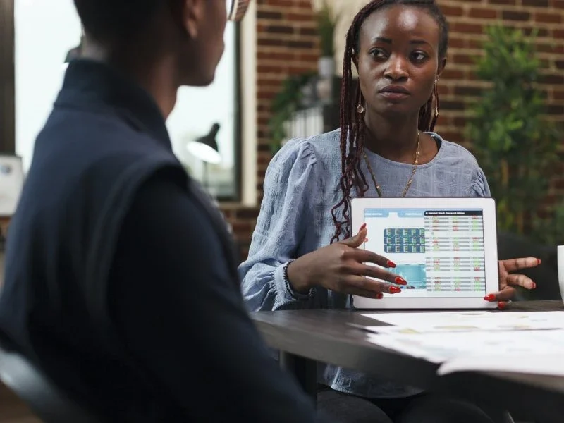 Accountants for Day Traders – Client Meeting Expert accountant for day traders explaining financial charts and tax strategies using tablet device