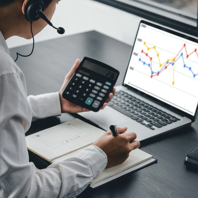 Accountants for Day Traders – Calculations Certified accountant for day traders working with calculator reviewing trading profits and tax records
