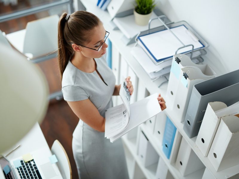 Office girl checking bookkeeping and accounting papers in the office for forex traders