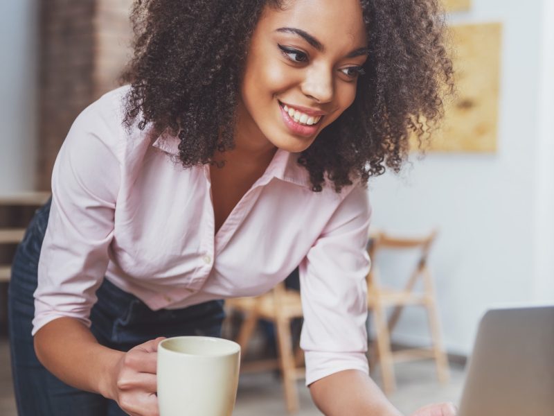 Office girl holding a cup in her hand while doing bookkeeping