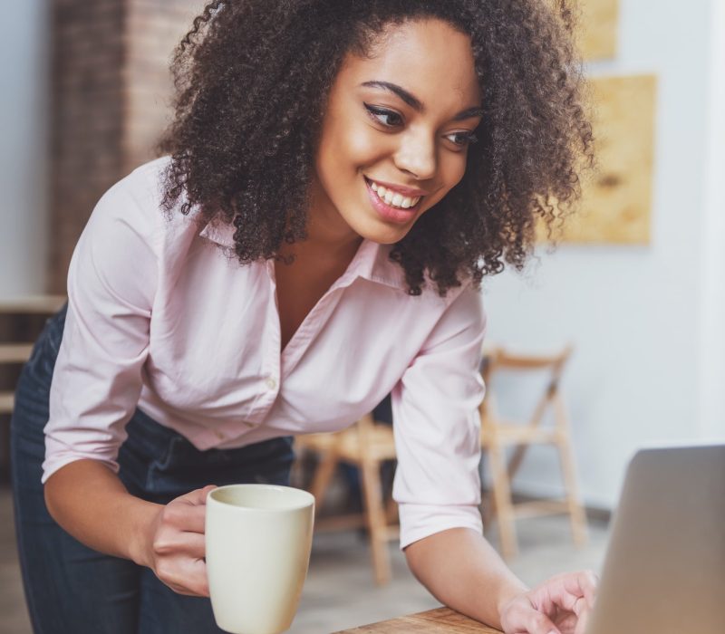 Office girl holding a cup in her hand while doing bookkeeping