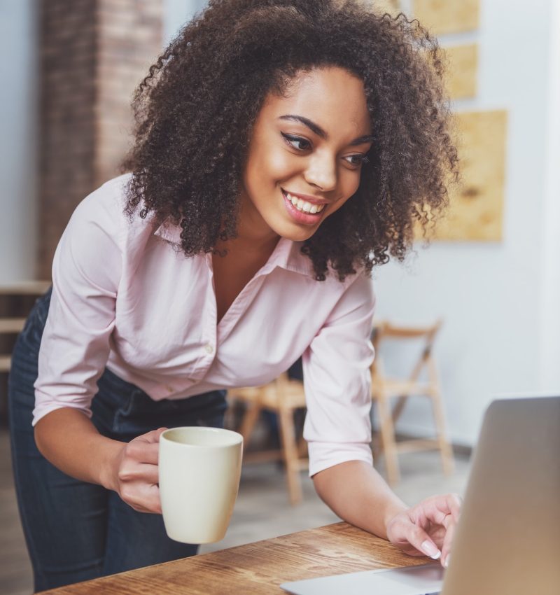 Office girl holding a cup in her hand while doing bookkeeping