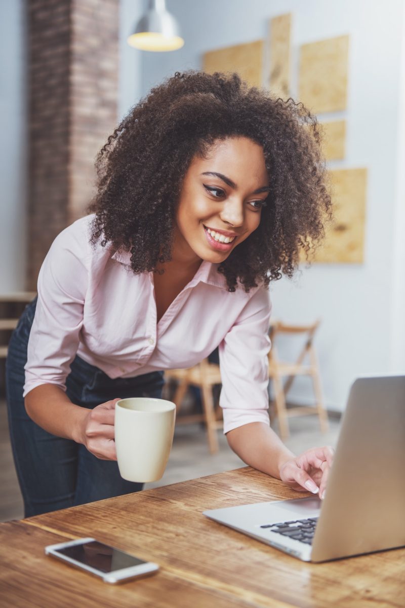 Office girl holding a cup in her hand while doing bookkeeping