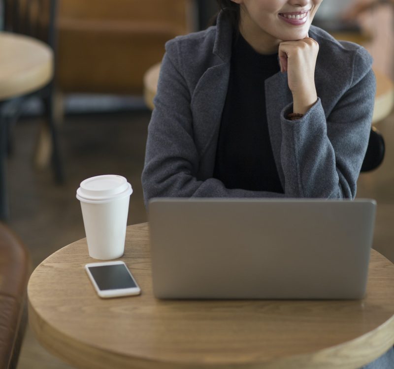 Businesswoman using laptop at the airport for bookkeeping