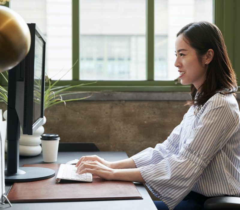 Chinese woman working at a computer in an office as an accountant and bookkeeper