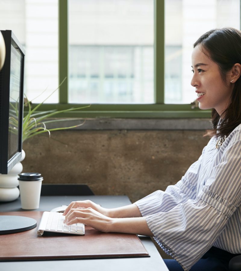 Chinese woman working at a computer in an office as an accountant and bookkeeper