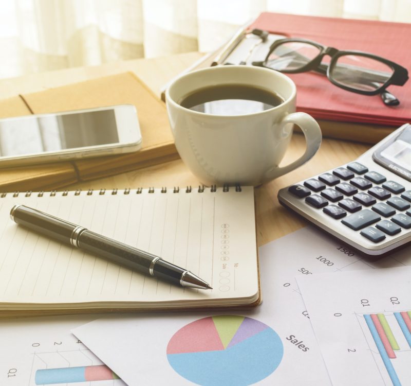 Desk office business financial accounting calculate, Graph analysis Office desk with a calculator, notepad and pen, a cup, glasses, and accountant graphs
