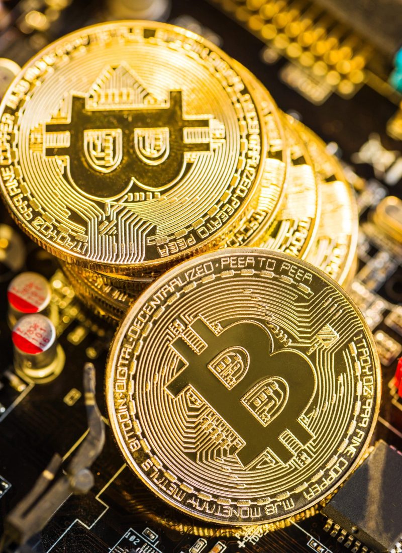 Golden bitcoins. Cryptocurrency on computer motherboard.