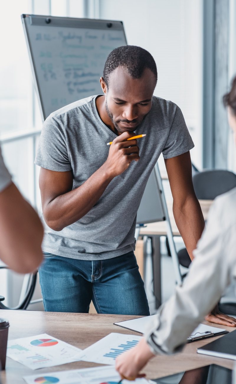 Man holding a pencil, thinking about how to solve accounting problems