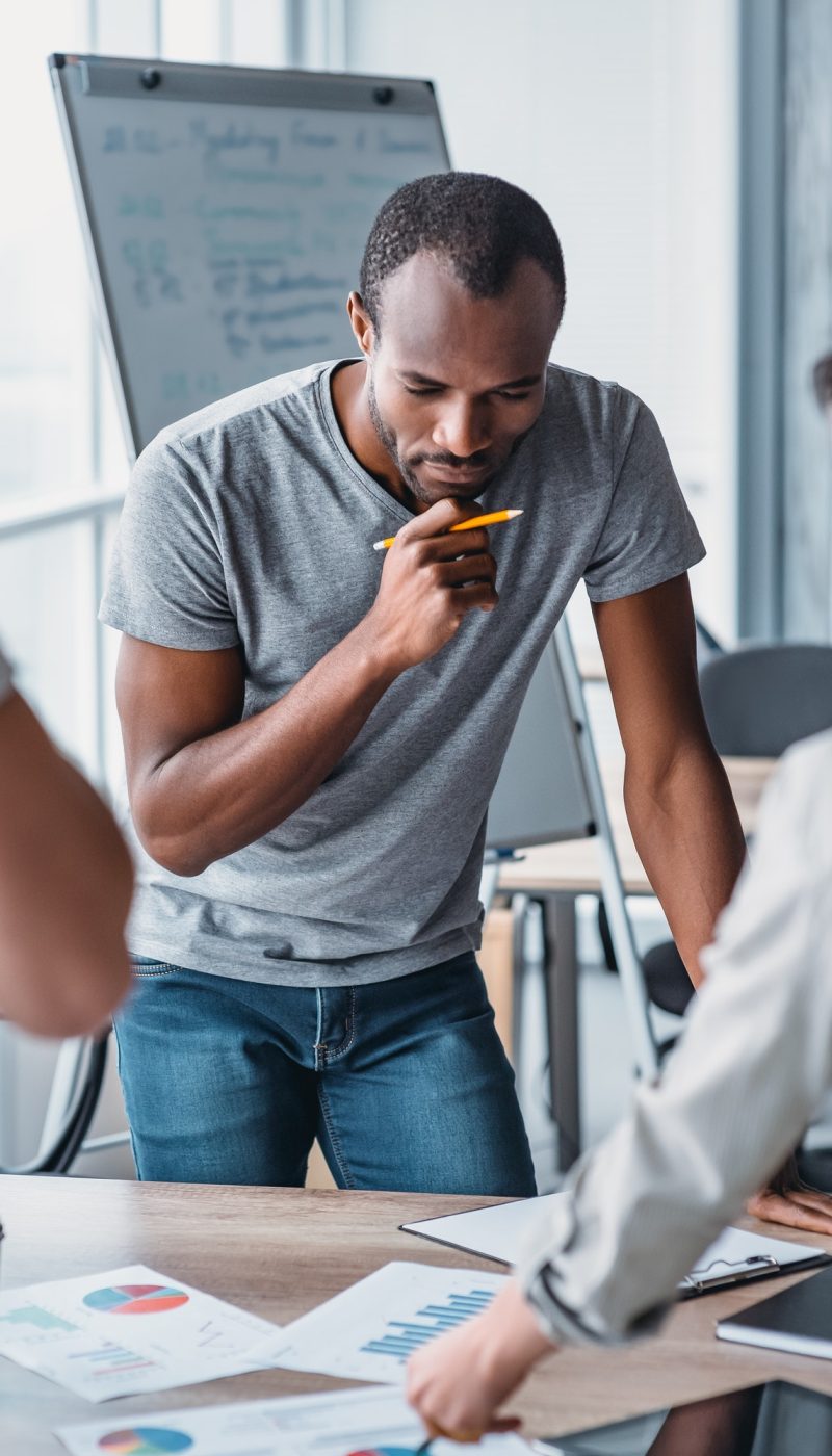 Man holding a pencil, thinking about how to solve accounting problems