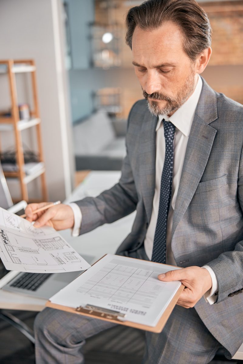 Handsome bearded man studying documents at work