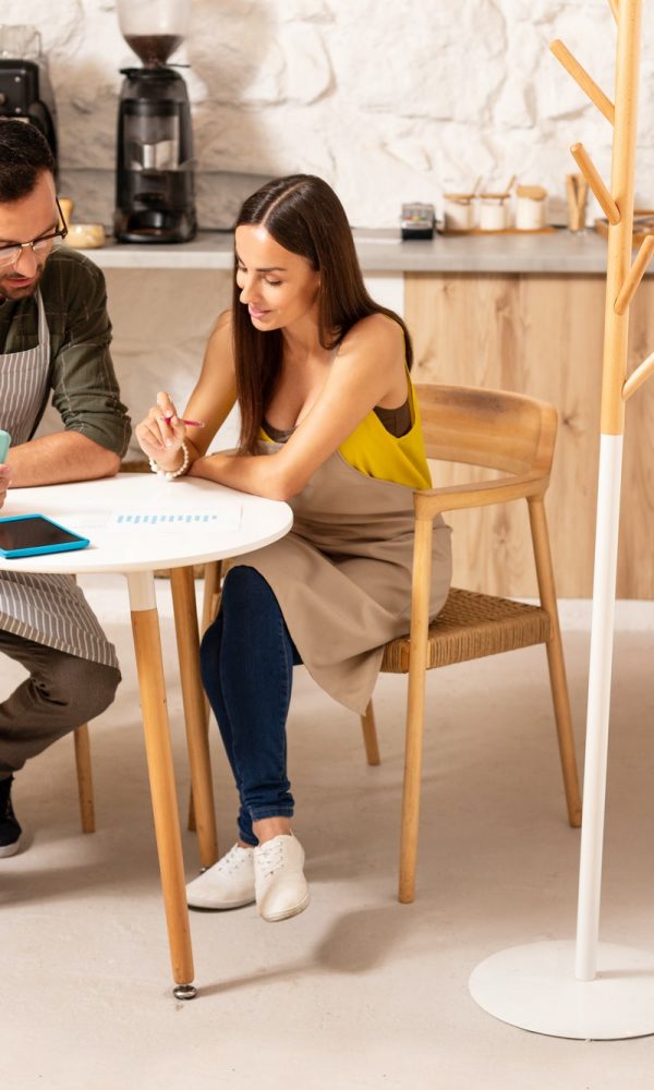Husband helping wife with accounting after opening cafeteria Boy teaching accounting and bookkeeping to the girl
