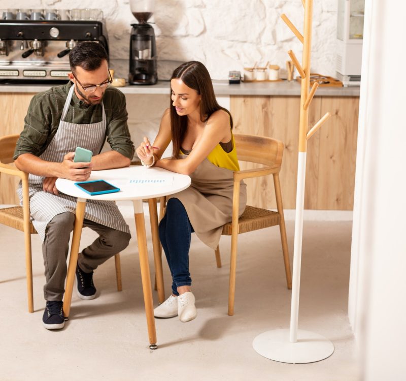 Husband helping wife with accounting after opening cafeteria Boy teaching accounting and bookkeeping to the girl