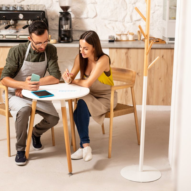Husband helping wife with accounting after opening cafeteria Boy teaching accounting and bookkeeping to the girl