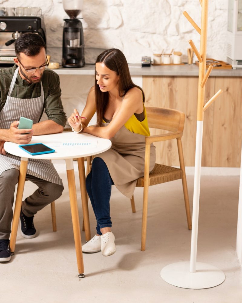 Husband helping wife with accounting after opening cafeteria Boy teaching accounting and bookkeeping to the girl