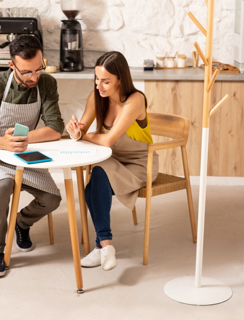 Husband helping wife with accounting after opening cafeteria Boy teaching accounting and bookkeeping to the girl