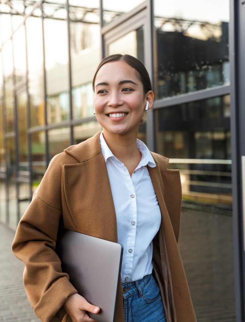 Image of young brunette asian woman holding laptop while walking, Tax Planning for Business, Tax Planning for Business Owners, Year-End Tax Planning