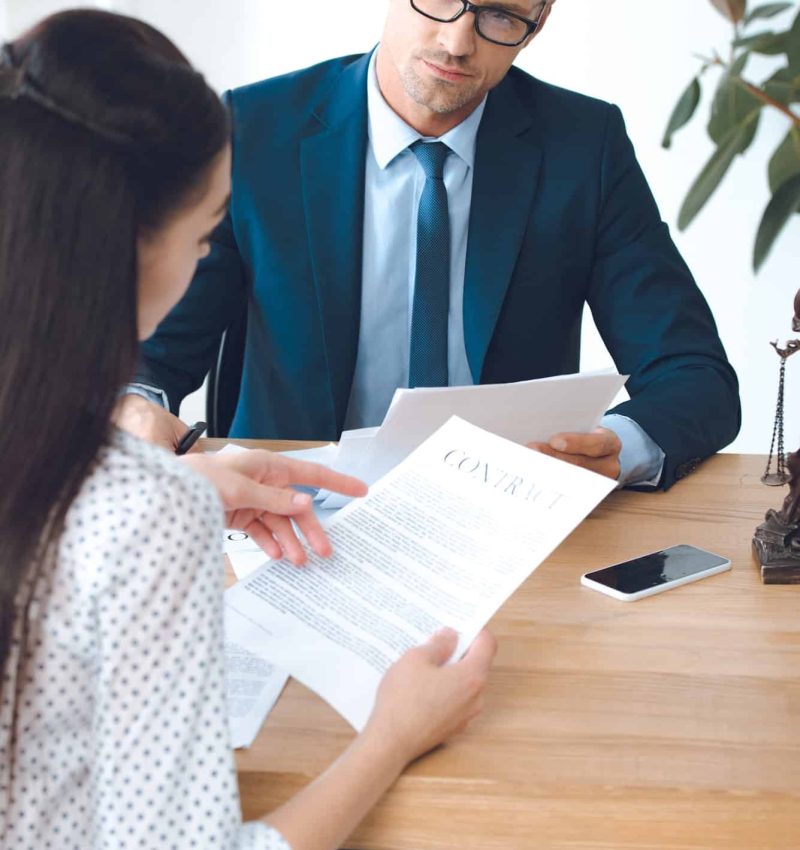 male-lawyer-looking-at-client-reading-contract.jpg