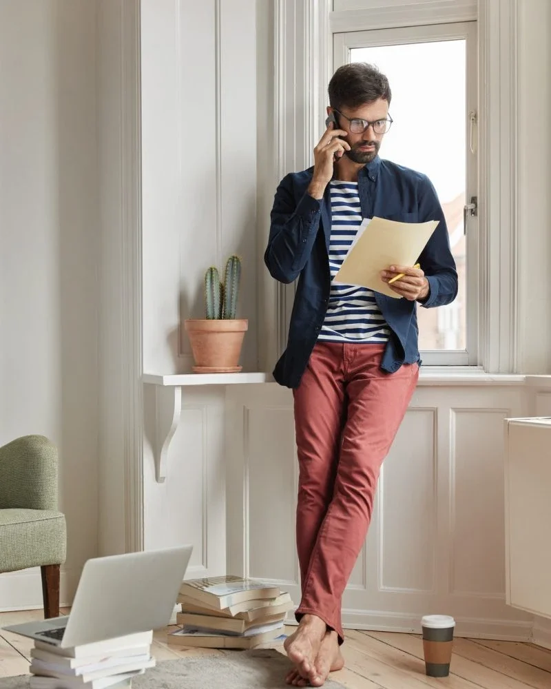 Accountants for Day Traders – Phone Consult Expert male accountant for day traders consulting clients by phone with trading papers in hand