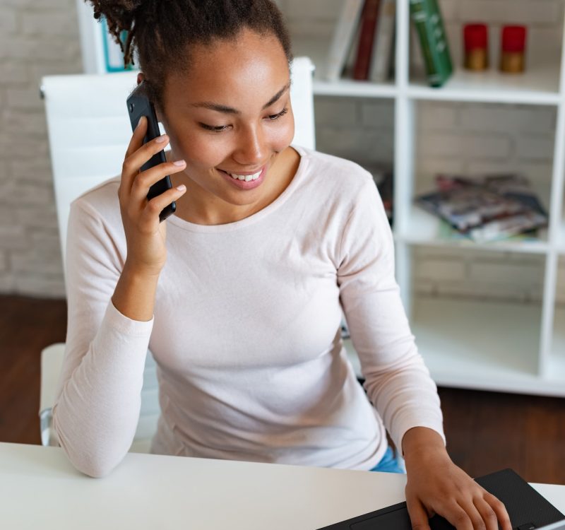 Smiling woman working on laptop in the office and talking on a smartphone . - Image, Accountants for Landlords