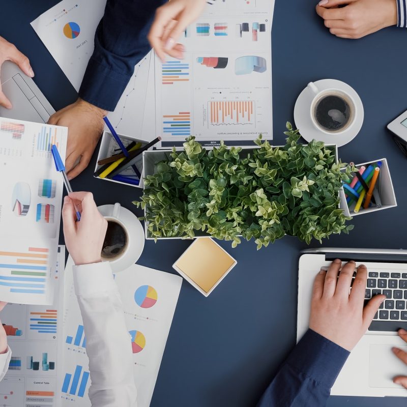 Top view of business teamwork analyzing company accounting paperwork