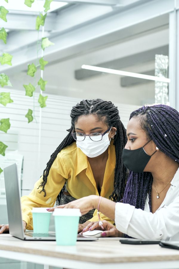 Two young women in the office, working together from the computer. Bookkeepers for real estate agents working together