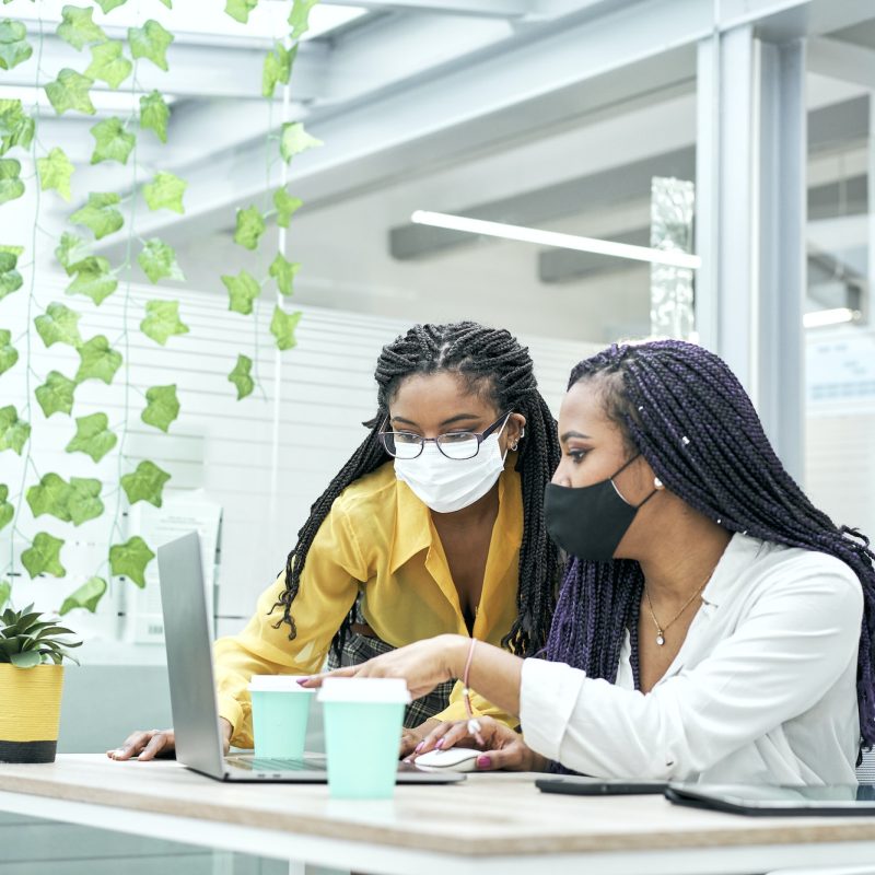 Two young women in the office, working together from the computer. Bookkeepers for real estate agents working together