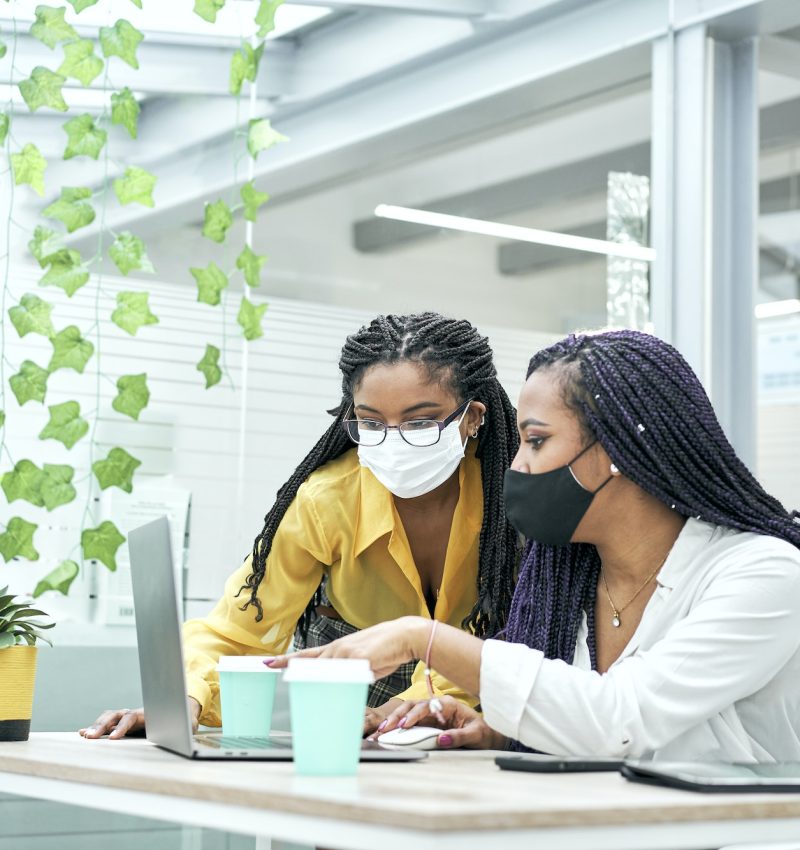 Two young women in the office, working together from the computer. Bookkeepers for real estate agents working together