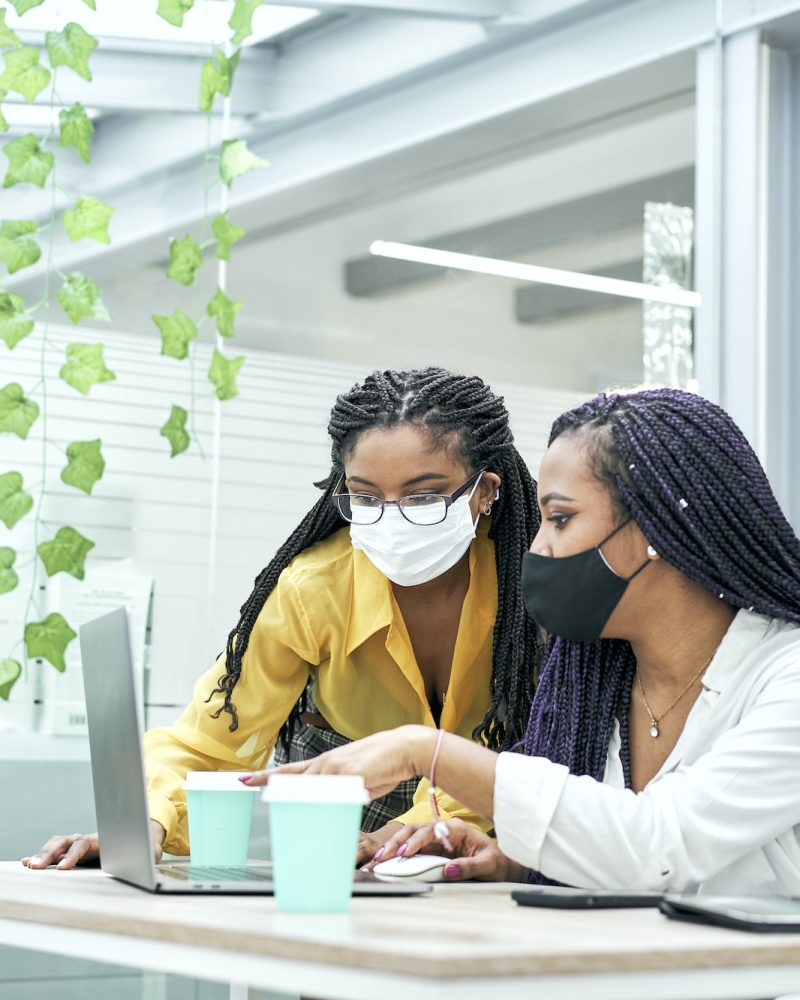 Two young women in the office, working together from the computer. Bookkeepers for real estate agents working together