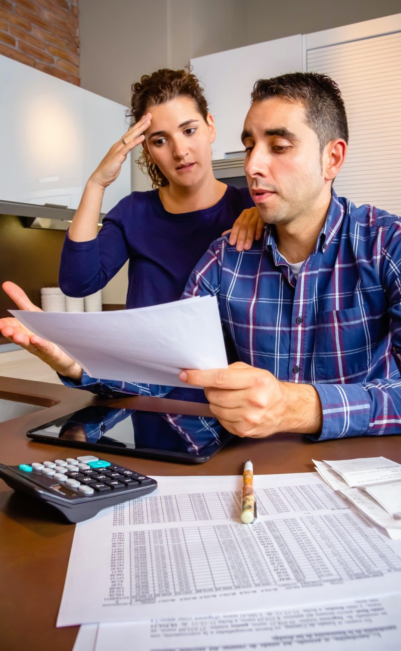 Unemployed young couple with debts reviewing their bank accounts Unemployed young couple with debts reviewing their bank accounts