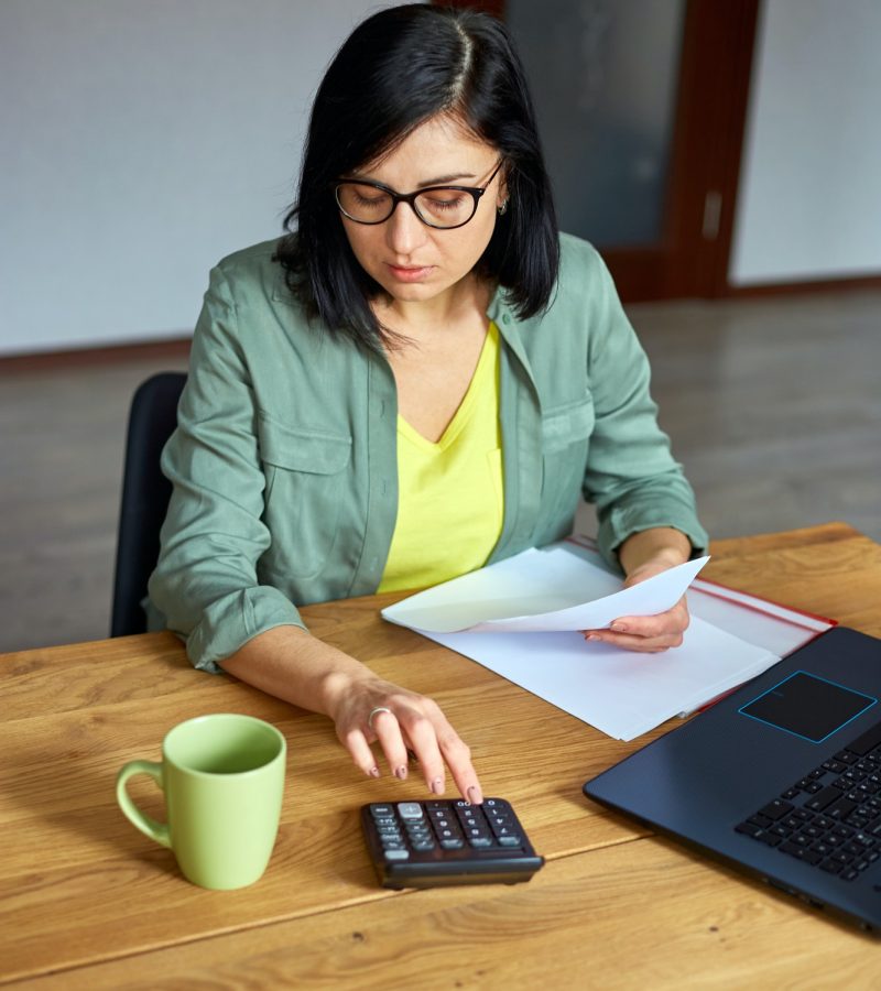 Woman accountant sit calculate expenses on calculator at wooden table, modern workplace, Small Business Accountant, Accountants For Hairdressers, Accountants For Estates