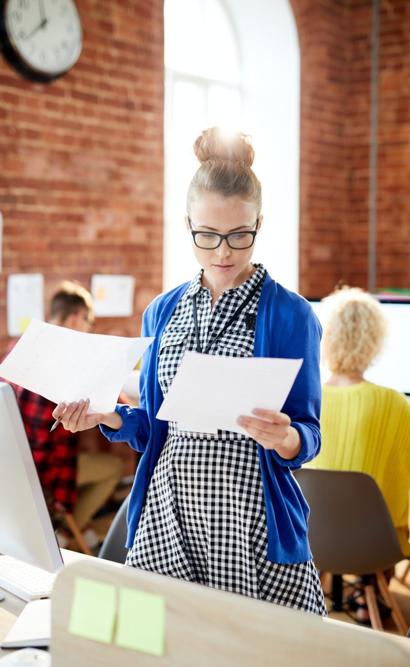airbnb accounting services An accountant girl looking at two accounting papers in the office