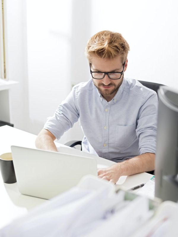 Young businessman using laptop at desk Accountant and bookkeeper using a laptop in the office