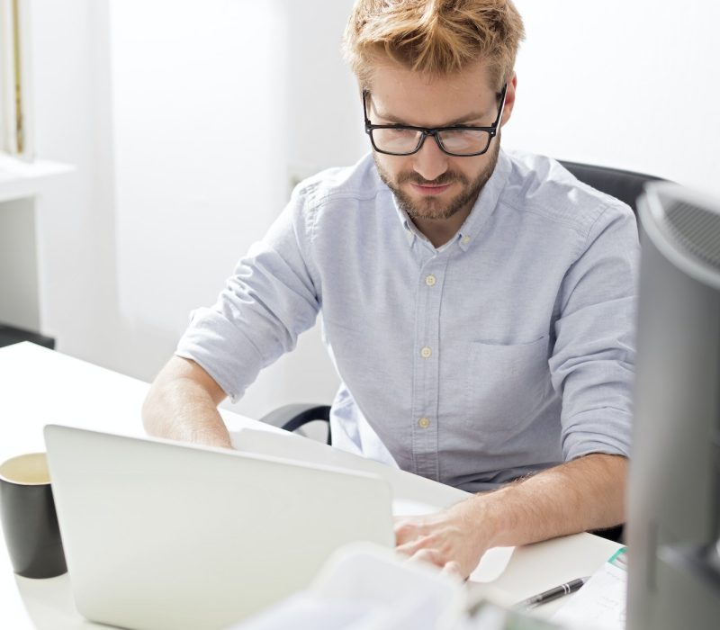 Young businessman using laptop at desk Accountant and bookkeeper using a laptop in the office