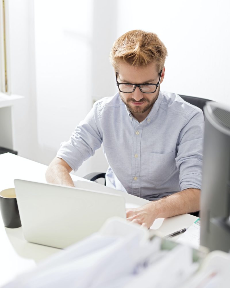 Young businessman using laptop at desk Accountant and bookkeeper using a laptop in the office
