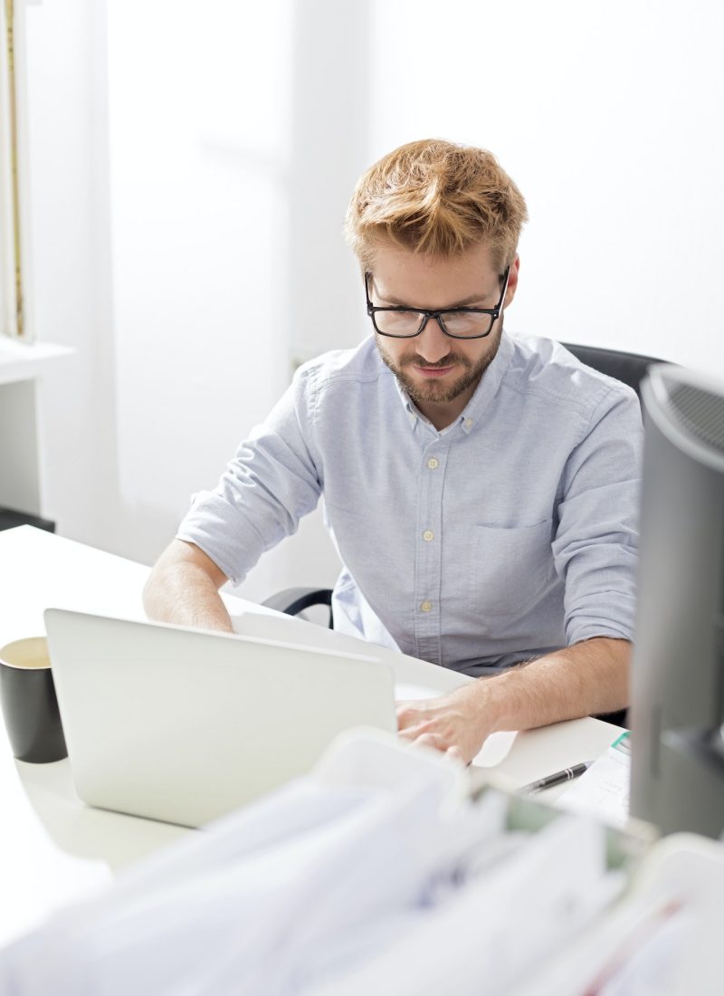 Young businessman using laptop at desk Accountant and bookkeeper using a laptop in the office