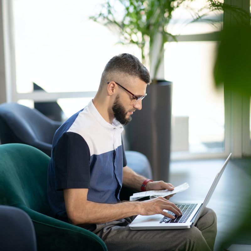 Young businessman working on laptop doing accounting