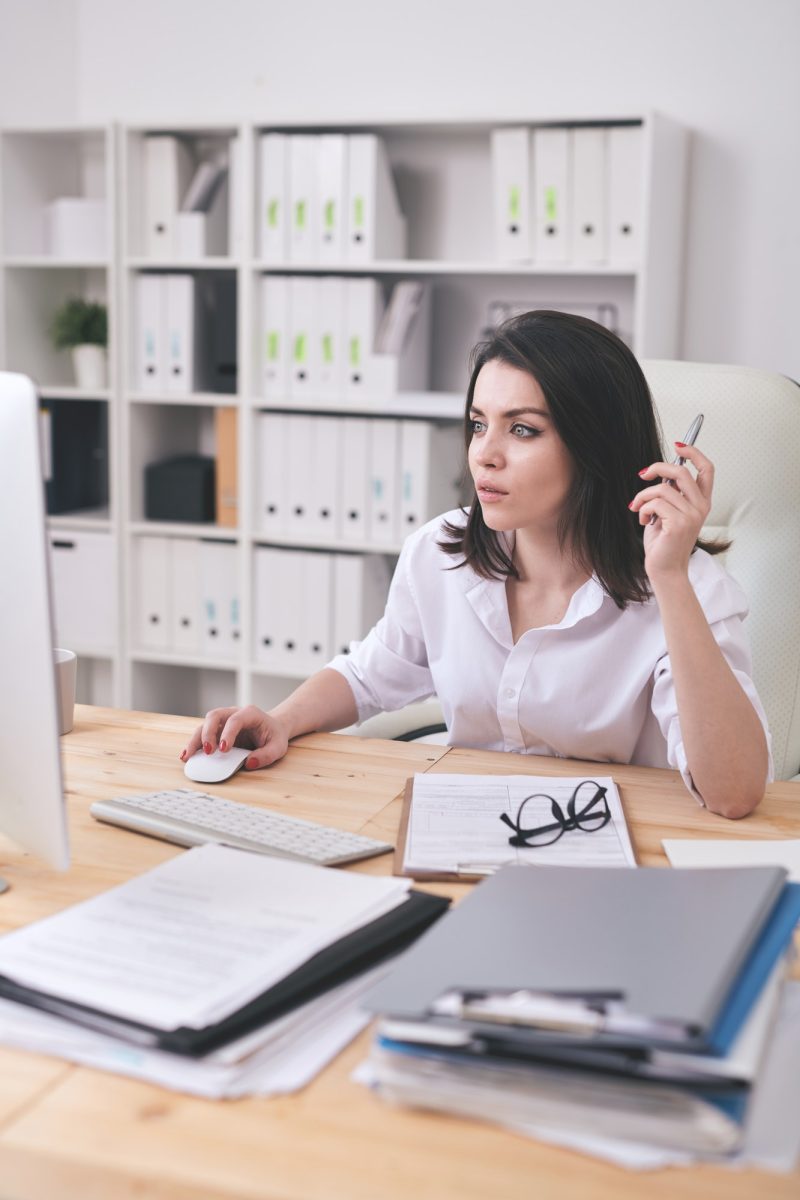 Young female accountant or financial analyst sitting in front of computer Young female accountant or financial analyst sitting in front of computer for bookkeeping services