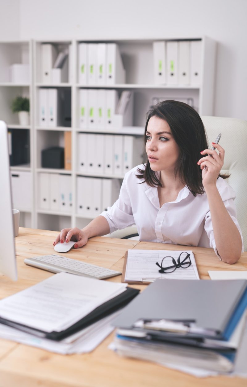 Young female accountant or financial analyst sitting in front of computer Young female accountant or financial analyst sitting in front of computer for bookkeeping services